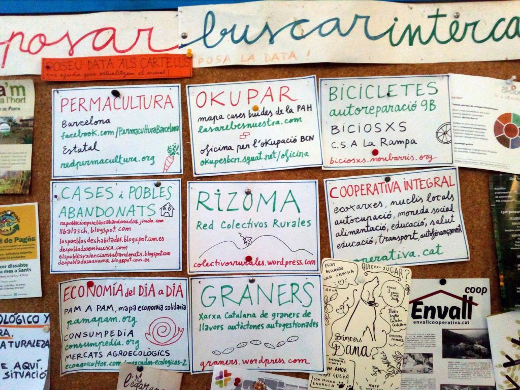 Ponto informativo do Centro Social Okupado de Can Masdeu, em Barcelona, com diversos anúncios relacionados com as «outras economias».